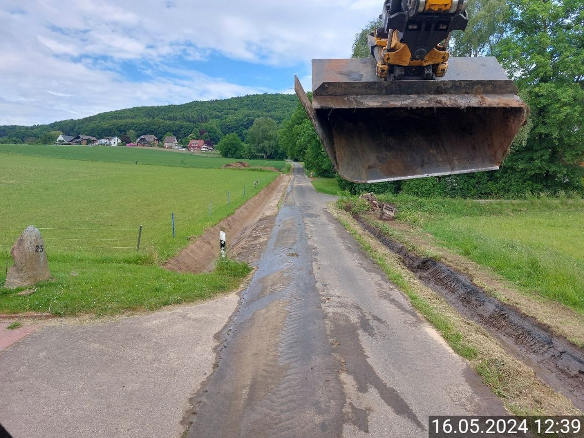 Eine Planierraupe bewegt Erde auf einer unbefestigten Straße.