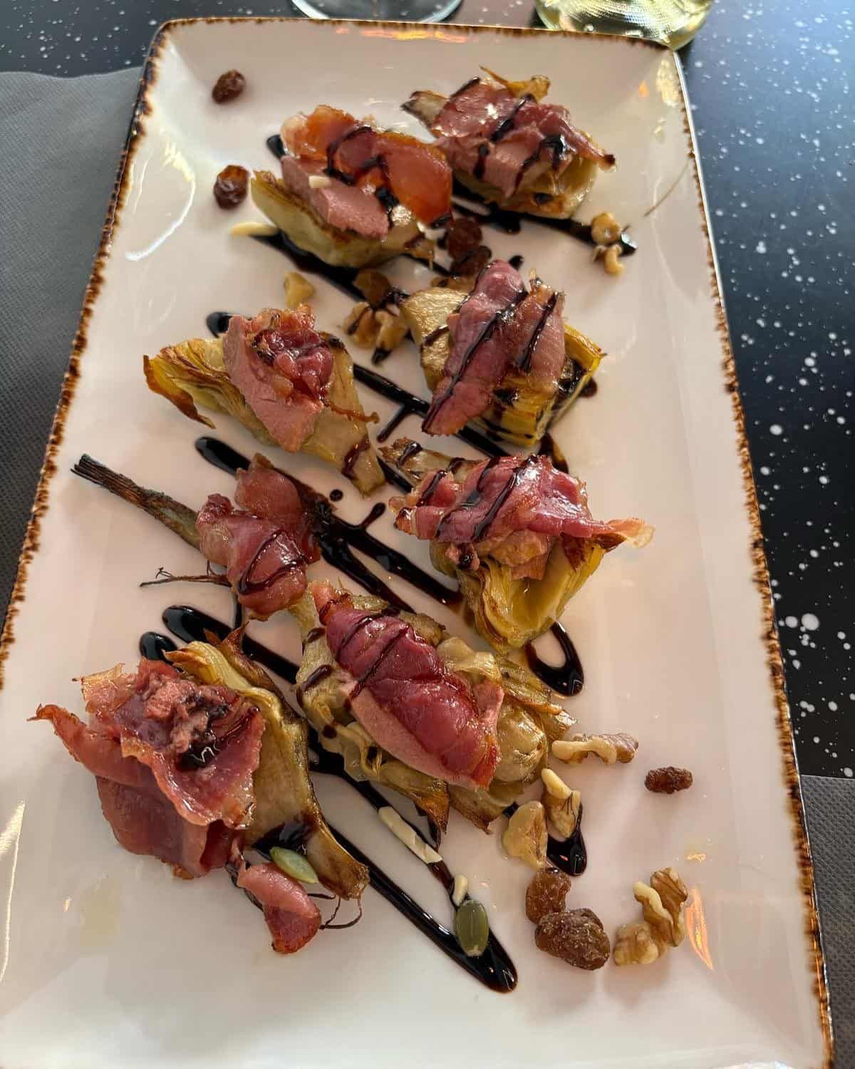 Aperitivo: Corazones de alcachofa cubiertos con prosciutto