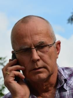 Ein Mann mit Brille telefoniert mit einem Mobiltelefon.