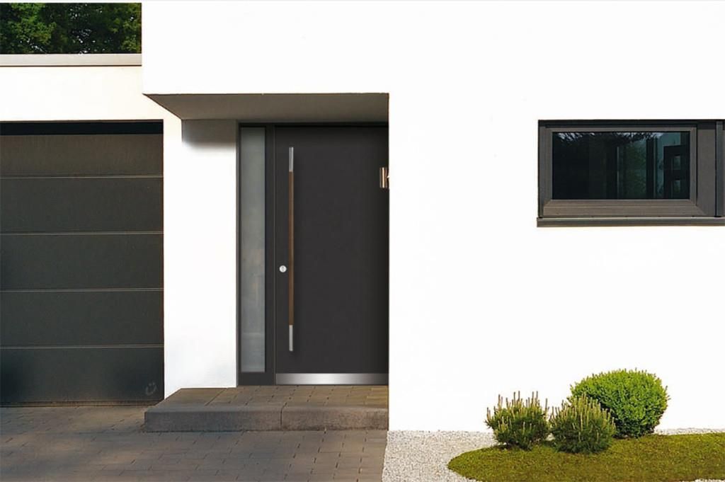 Modernes Hausäußeres mit dunkelgrauer Tür und Garage, weißen Wänden und kleinem Fenster.