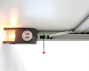An der Decke montierter Garagentoröffner mit eingeschalteter Lampe und Verbindungsarm.