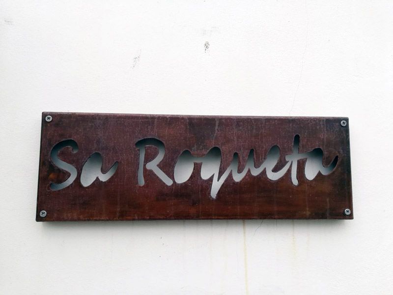 Letrero de madera con letras recortadas que dicen 