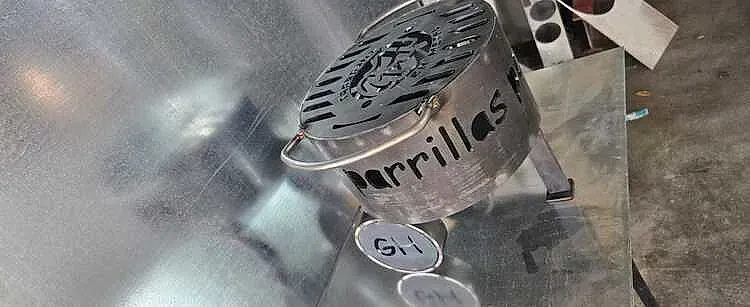 Una parrilla portátil de metal con la palabra 