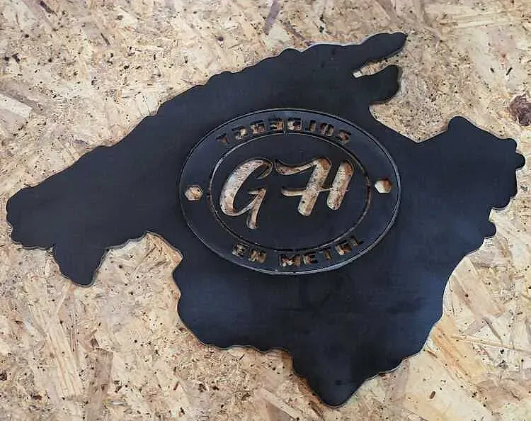 Letrero metálico negro de la isla de Mallorca con un logotipo circular en el centro que dice 