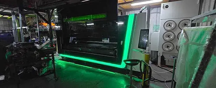Una gran máquina industrial con luces verdes en un entorno de taller.