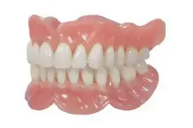 Un primer plano de una dentadura postiza con dientes blancos sobre un fondo blanco.