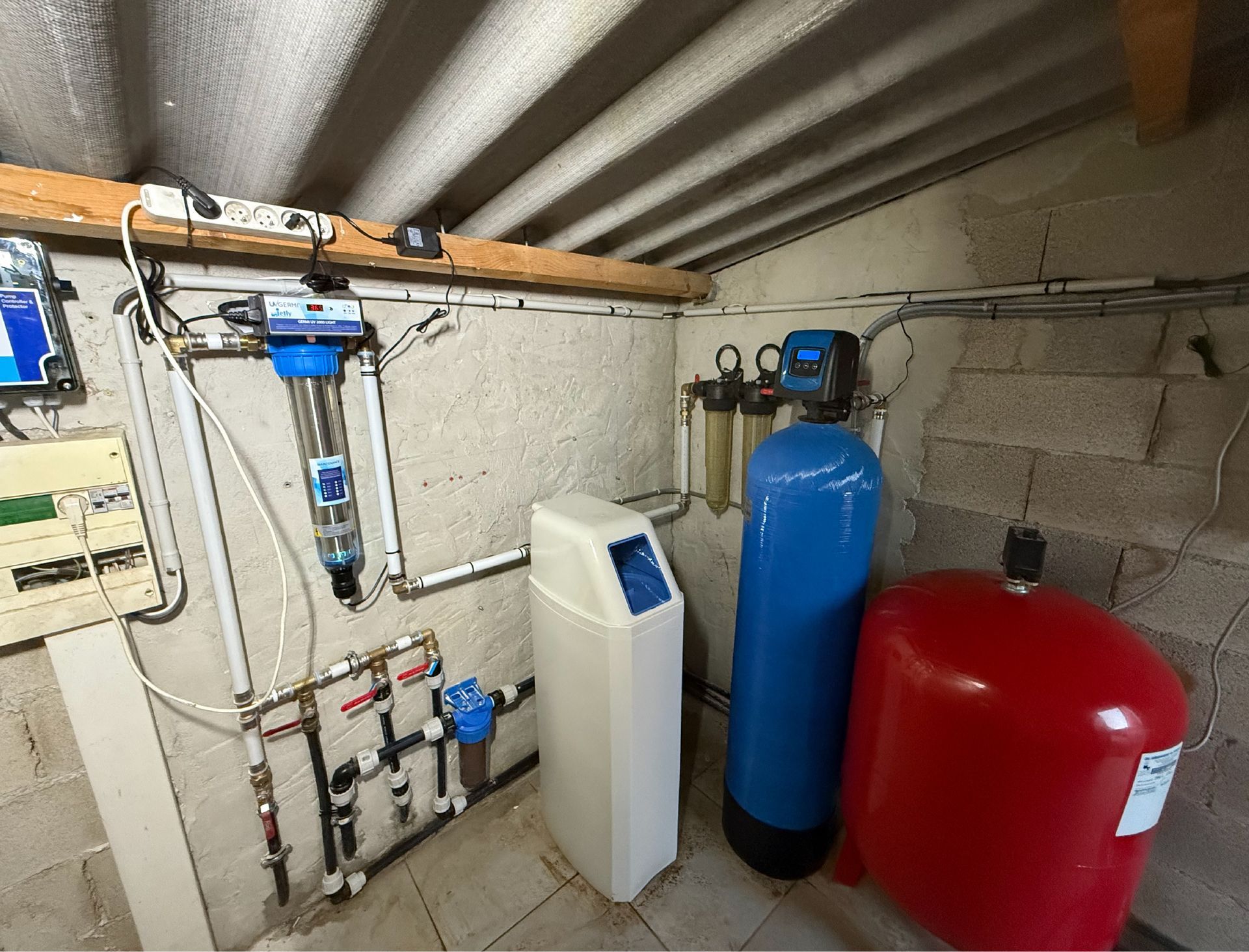 Système de filtration et de traitement de l'eau au sous-sol. Comprend des filtres, un adoucisseur et un réservoir sous pression.