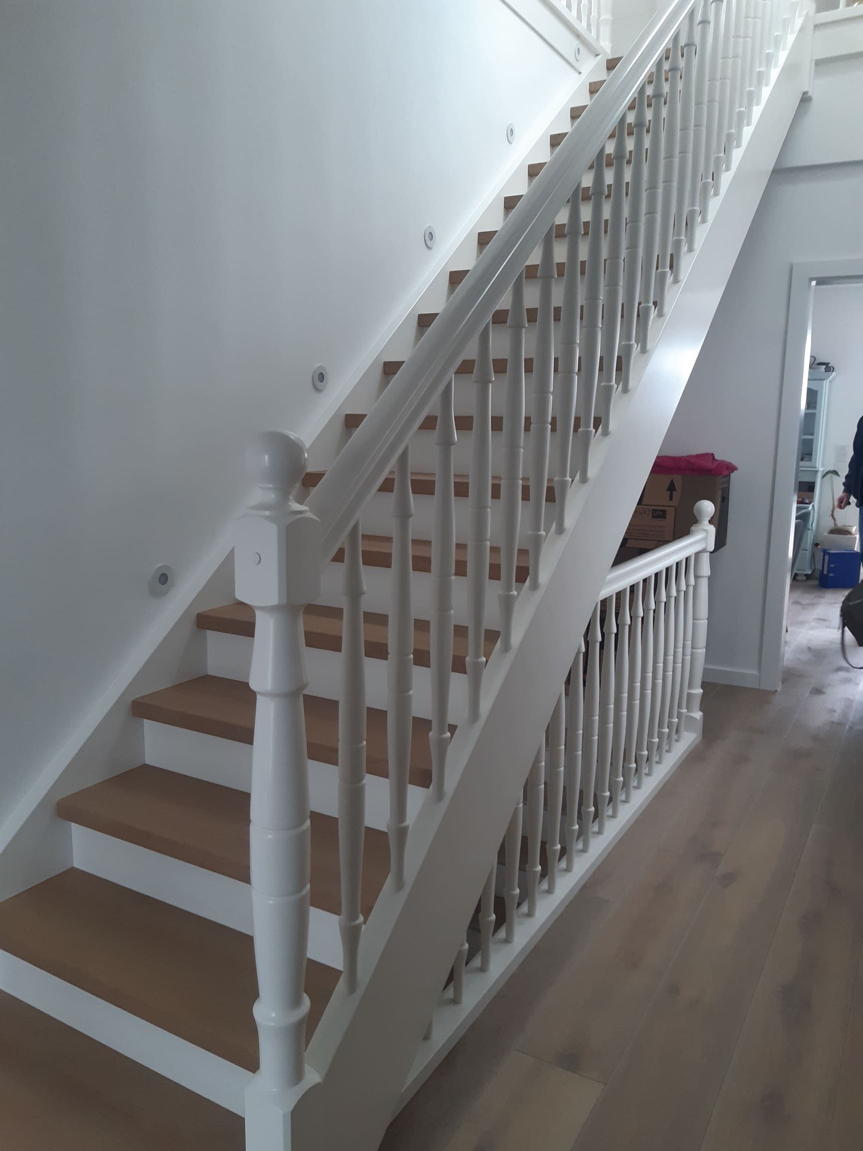 Massivholztreppe mit Stufen aus Eiche geräuchert und geölt, Wangen und Handlauf weiß lackiert.