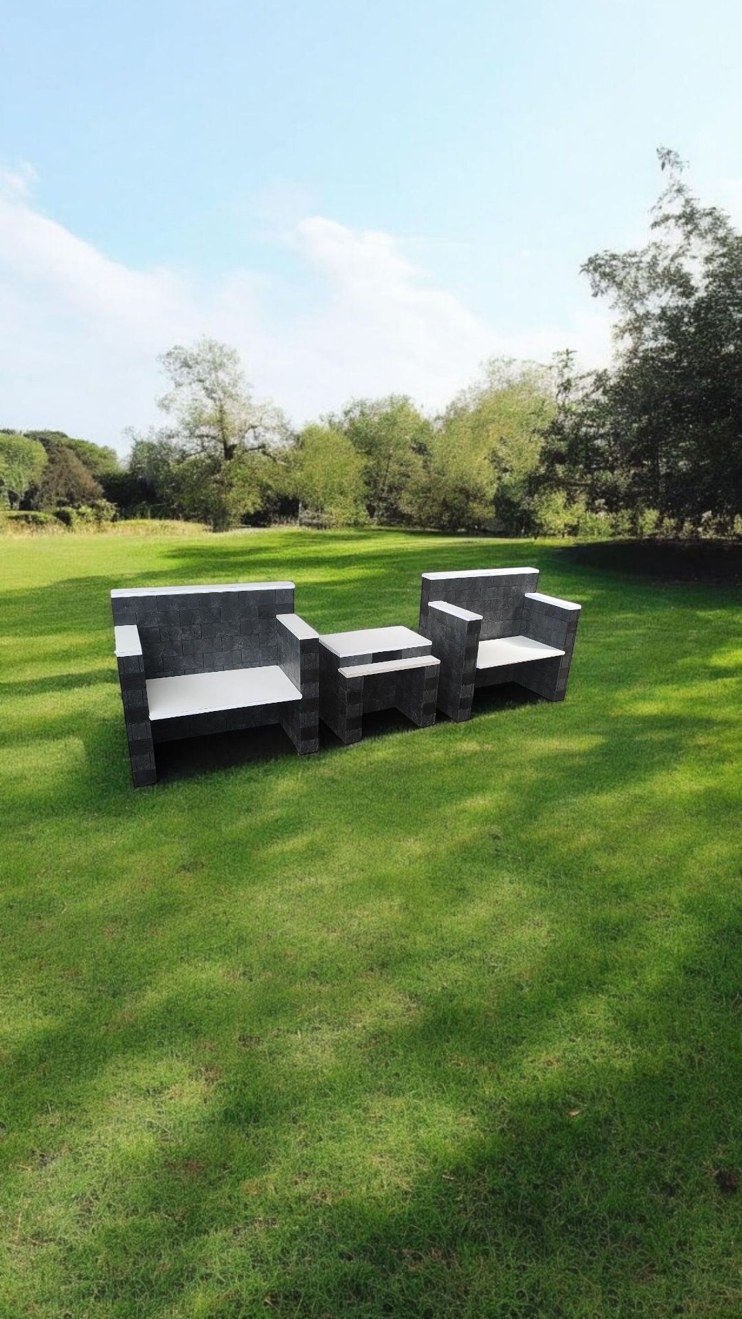 Dos sillas y una mesa están sentadas en medio de un exuberante campo verde.
