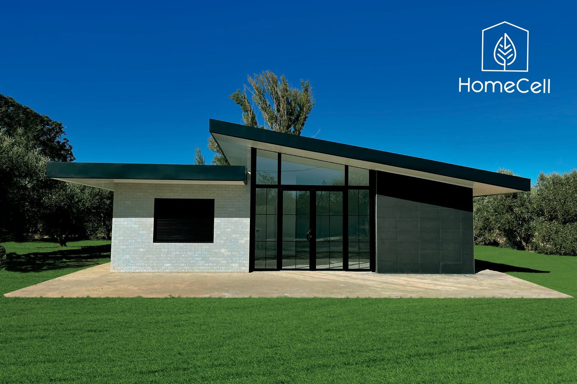 Una casa blanca con techo verde está situada encima de un exuberante campo verde.