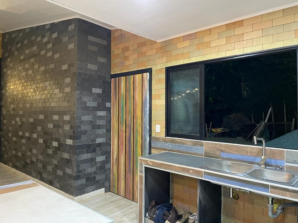 Una cocina con fregadero, estufa y ventana.