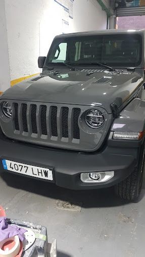 Un jeep wrangler está estacionado en un garaje.
