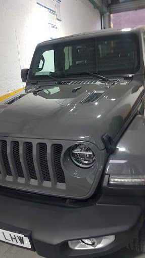 Un jeep gris está estacionado en un garaje.