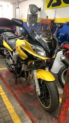 Una motocicleta amarilla y negra está estacionada en un garaje.