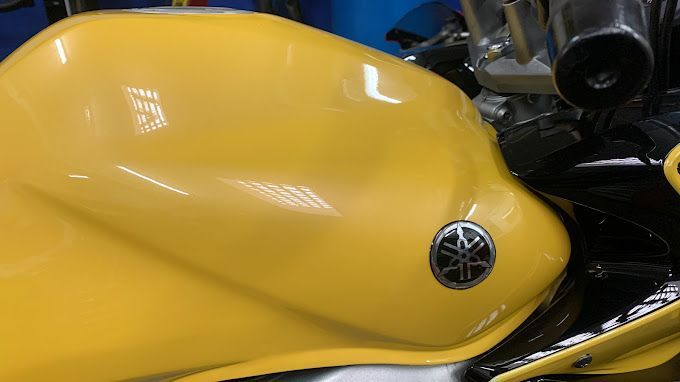 Una motocicleta Yamaha amarilla está estacionada en un garaje.