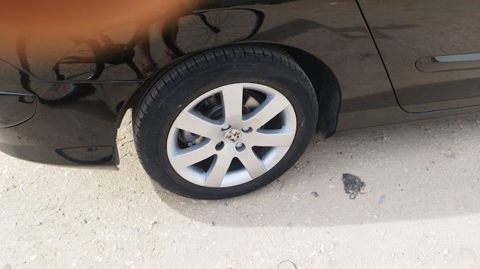 Un primer plano de una rueda de automóvil en un camino de tierra.