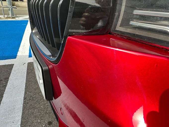 Un coche rojo está estacionado en un lugar de estacionamiento para discapacitados.
