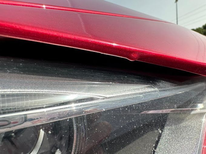 Un primer plano del faro de un coche rojo.