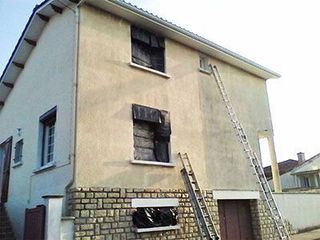Traitement de l'humidité en façade d'une maison en cours montrant une partie saine et une partie sombre