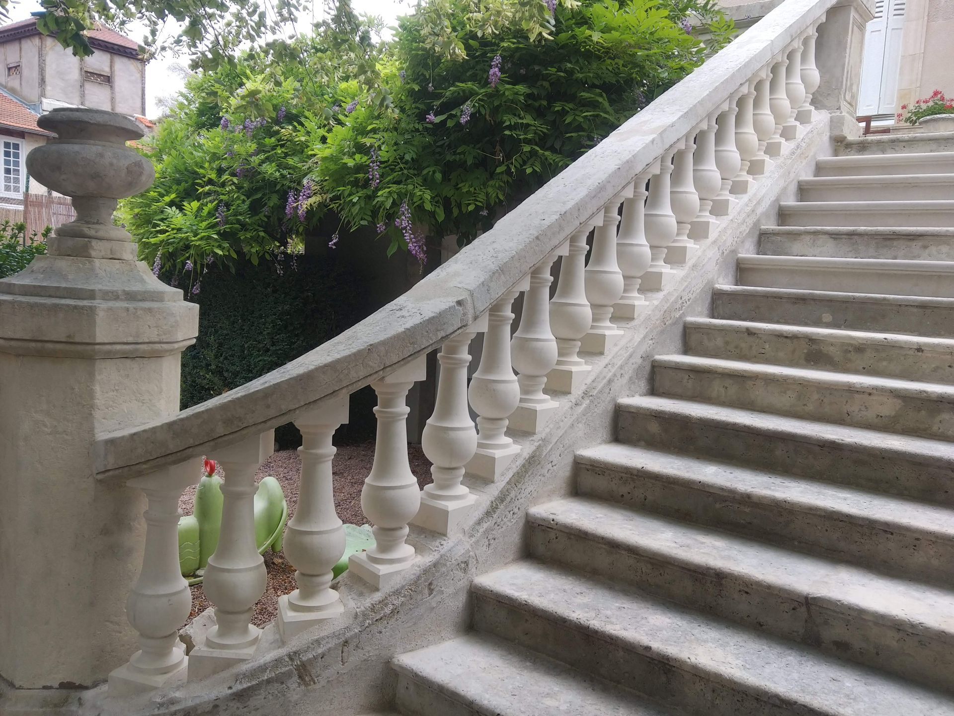 Escalier en pierre avec balustrade incurvée et verdure à côté