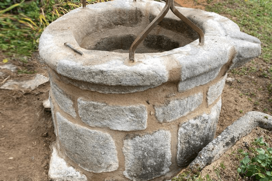 Puits en pierre avec une corde dans un cadre extérieur