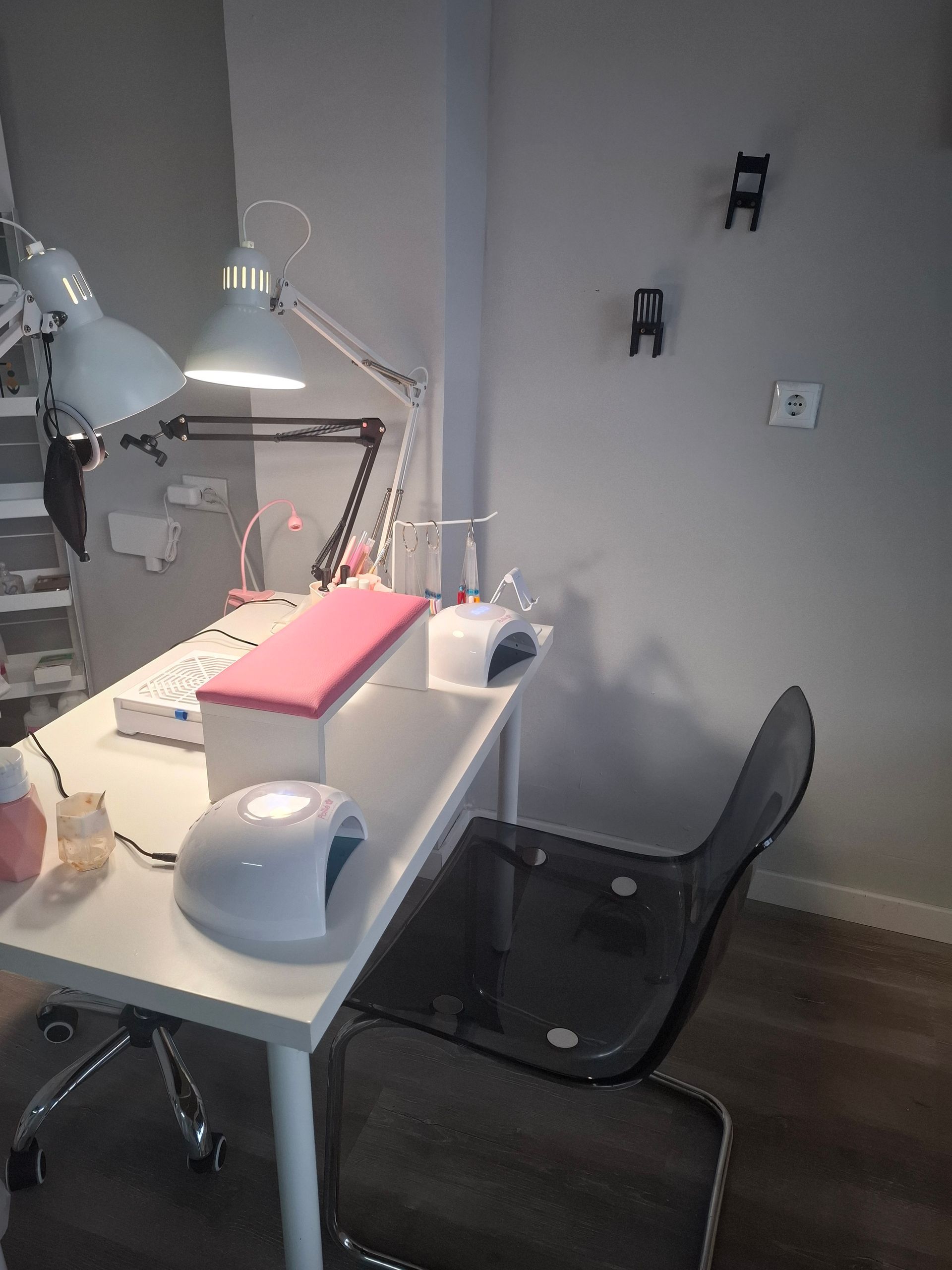 Una mesa de manicura con una lámpara y una silla en una habitación.