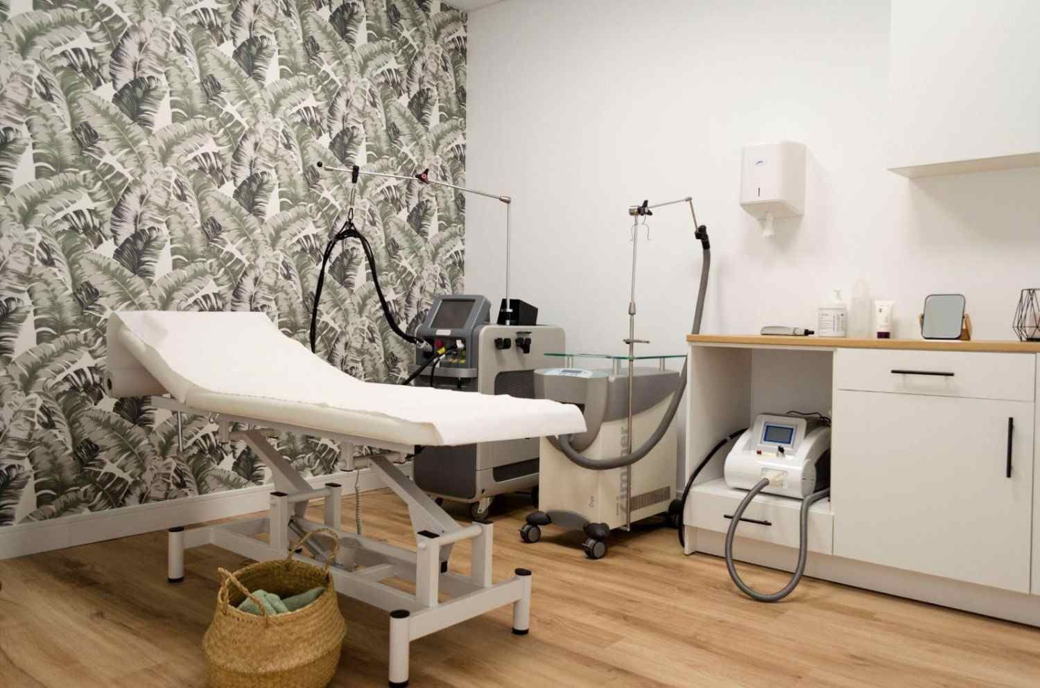 Mujer recibiendo un tratamiento facial con un dispositivo portátil en un entorno de spa.