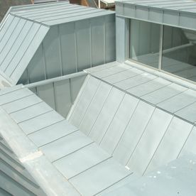 Primer plano de un techo de metal en un edificio moderno, mostrando planos angulares en varios tamaños.