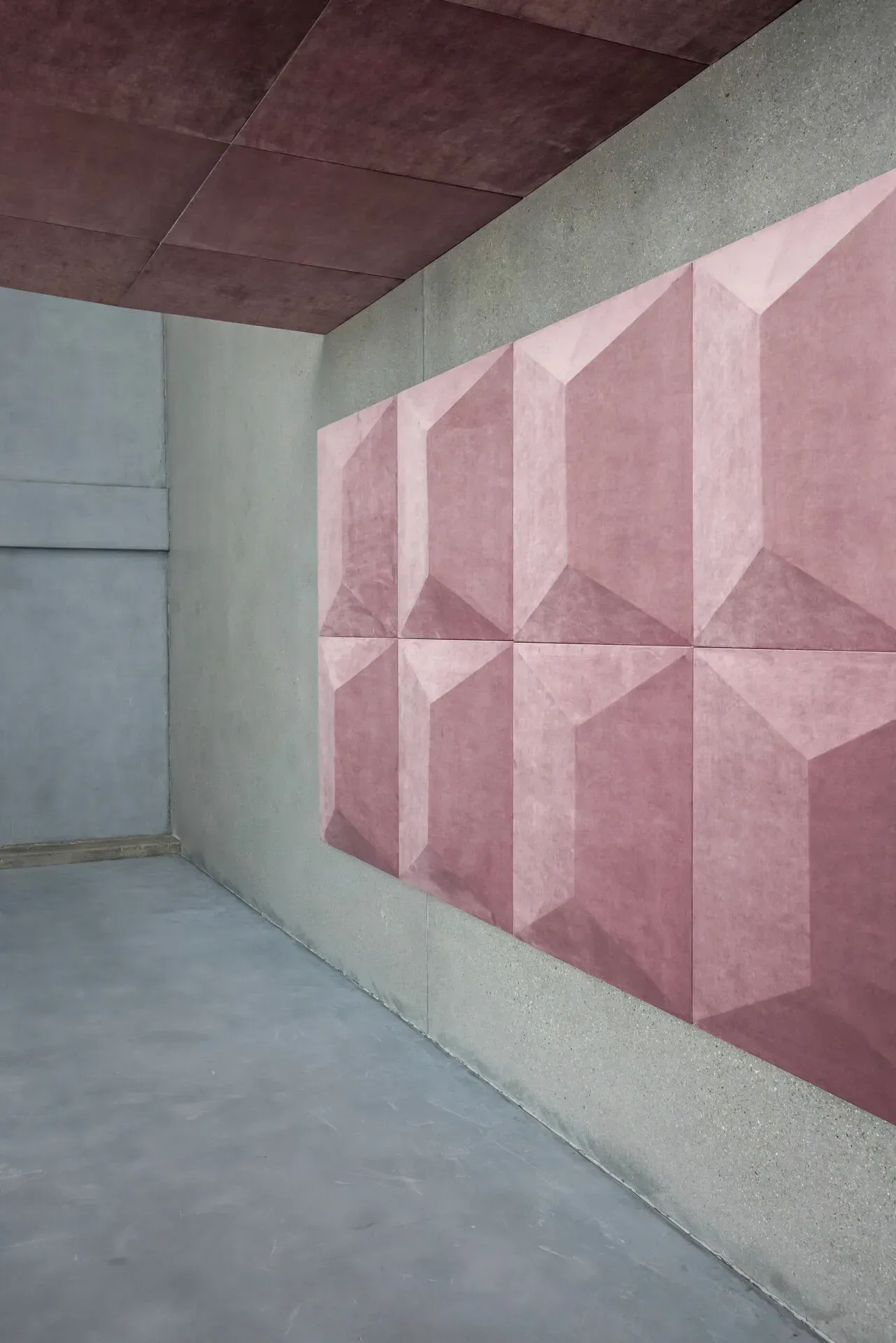 Wohnzimmer mit grauem Sofa, schwarzem Drahtstuhl und Holzboden. Kissen, Couchtisch und ein großes Kunstwerk.