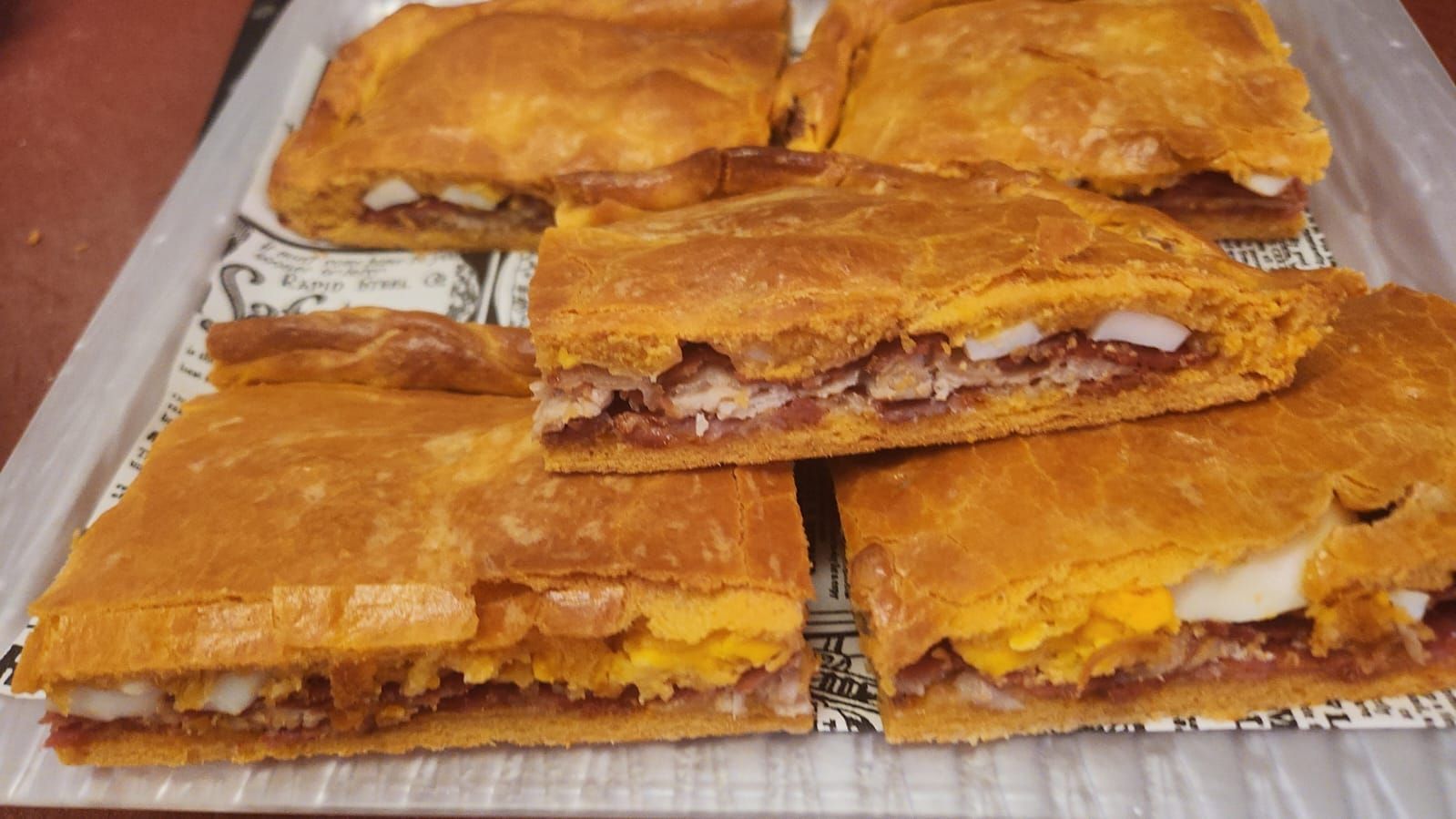 Un montón de sándwiches están apilados uno encima del otro sobre una mesa.