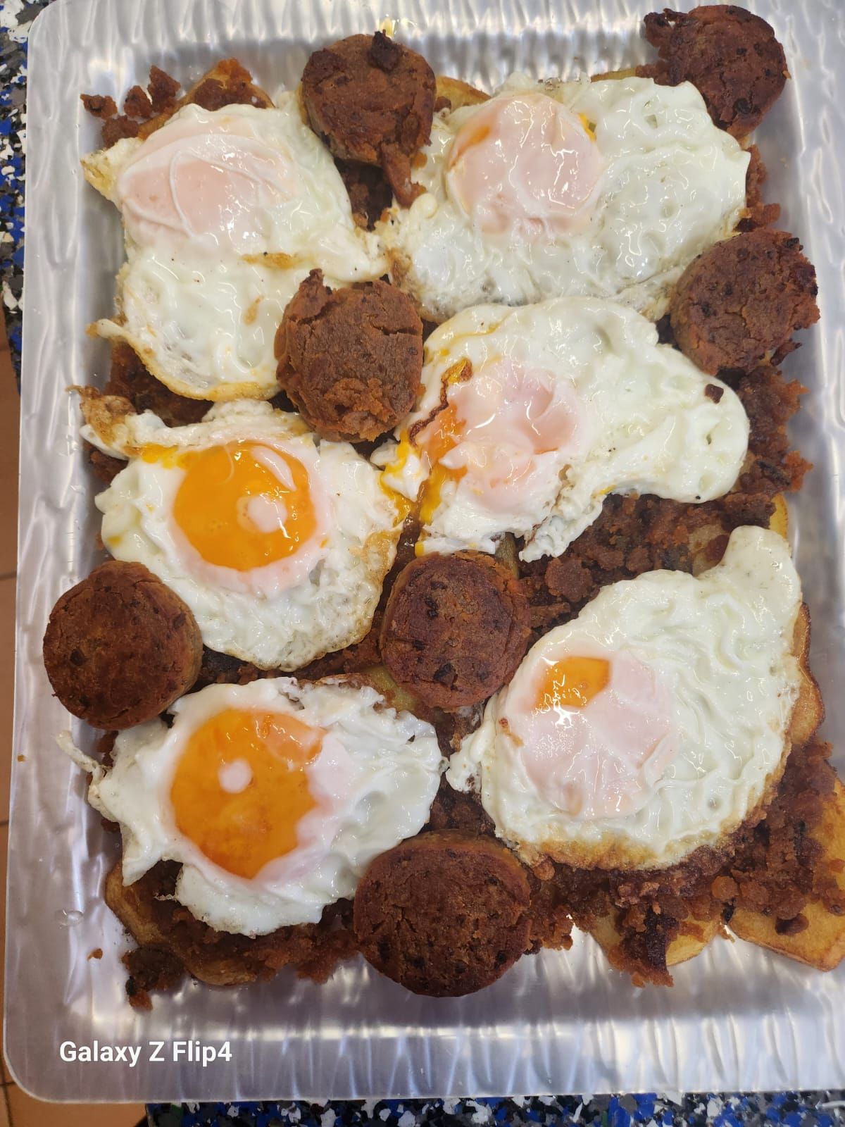 Una bandeja de comida con huevos y albóndigas en una mesa.