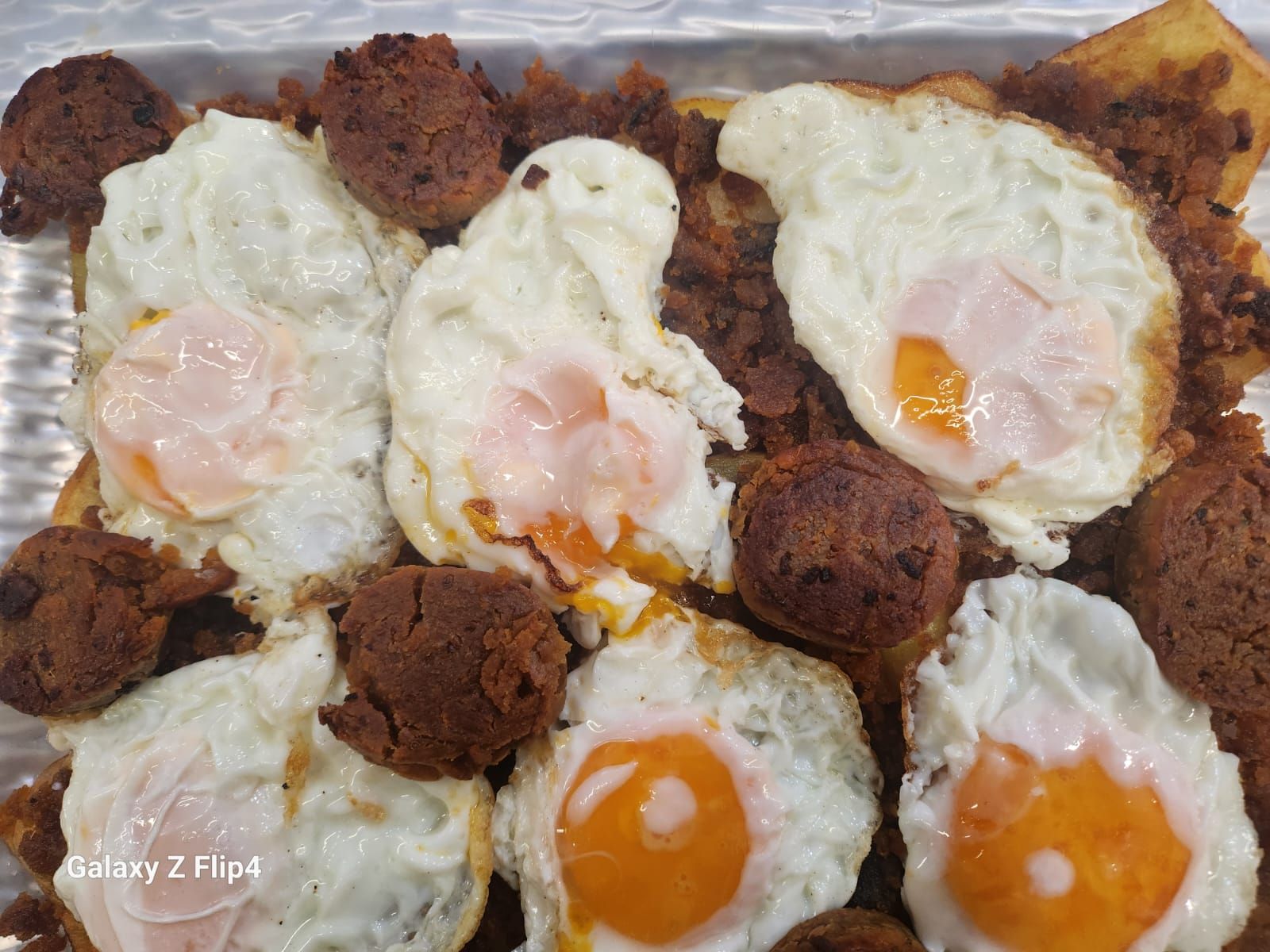 Un primer plano de un plato de comida con huevos y salchichas.