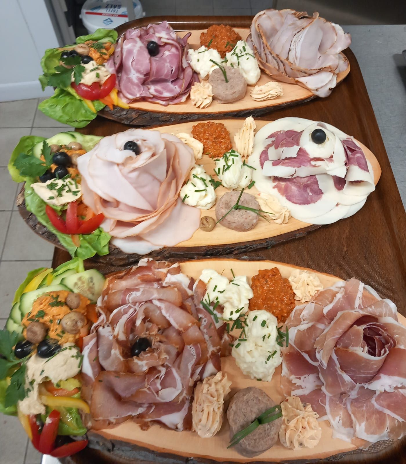 Tres tablas de madera llenas de diferentes tipos de carnes y verduras.