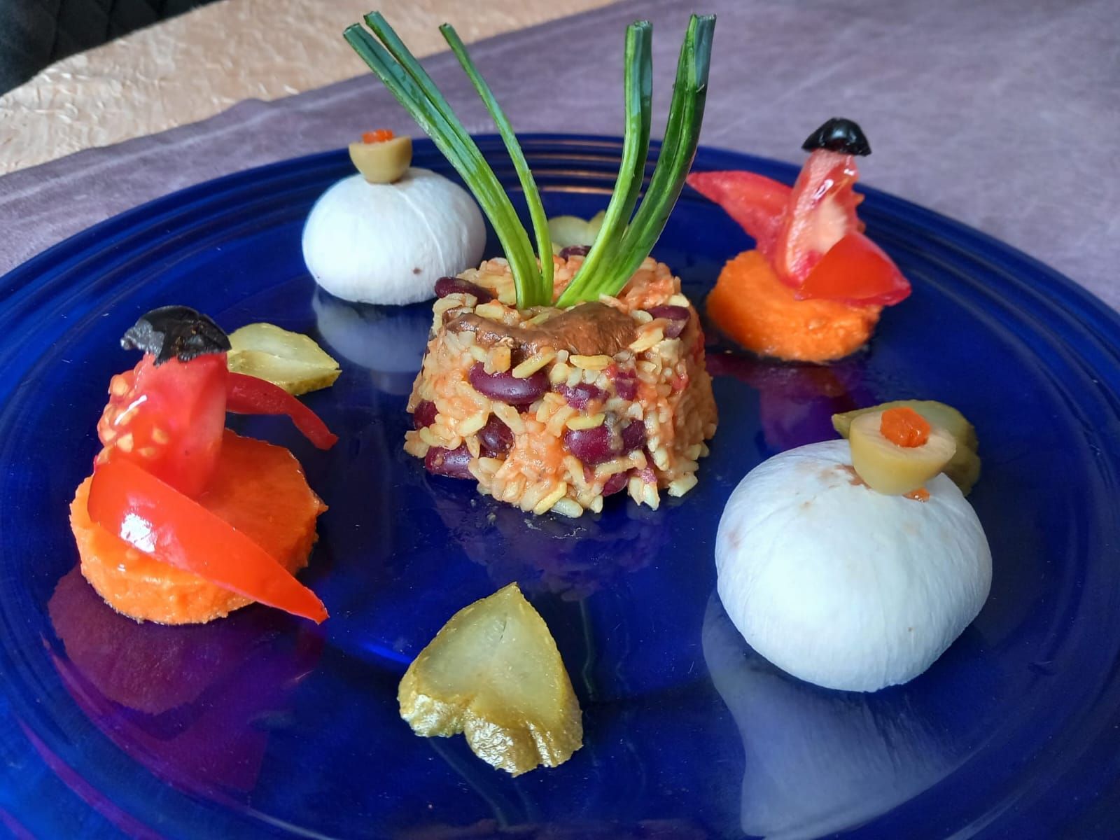 Un plato azul cubierto con una variedad de verduras y arroz.