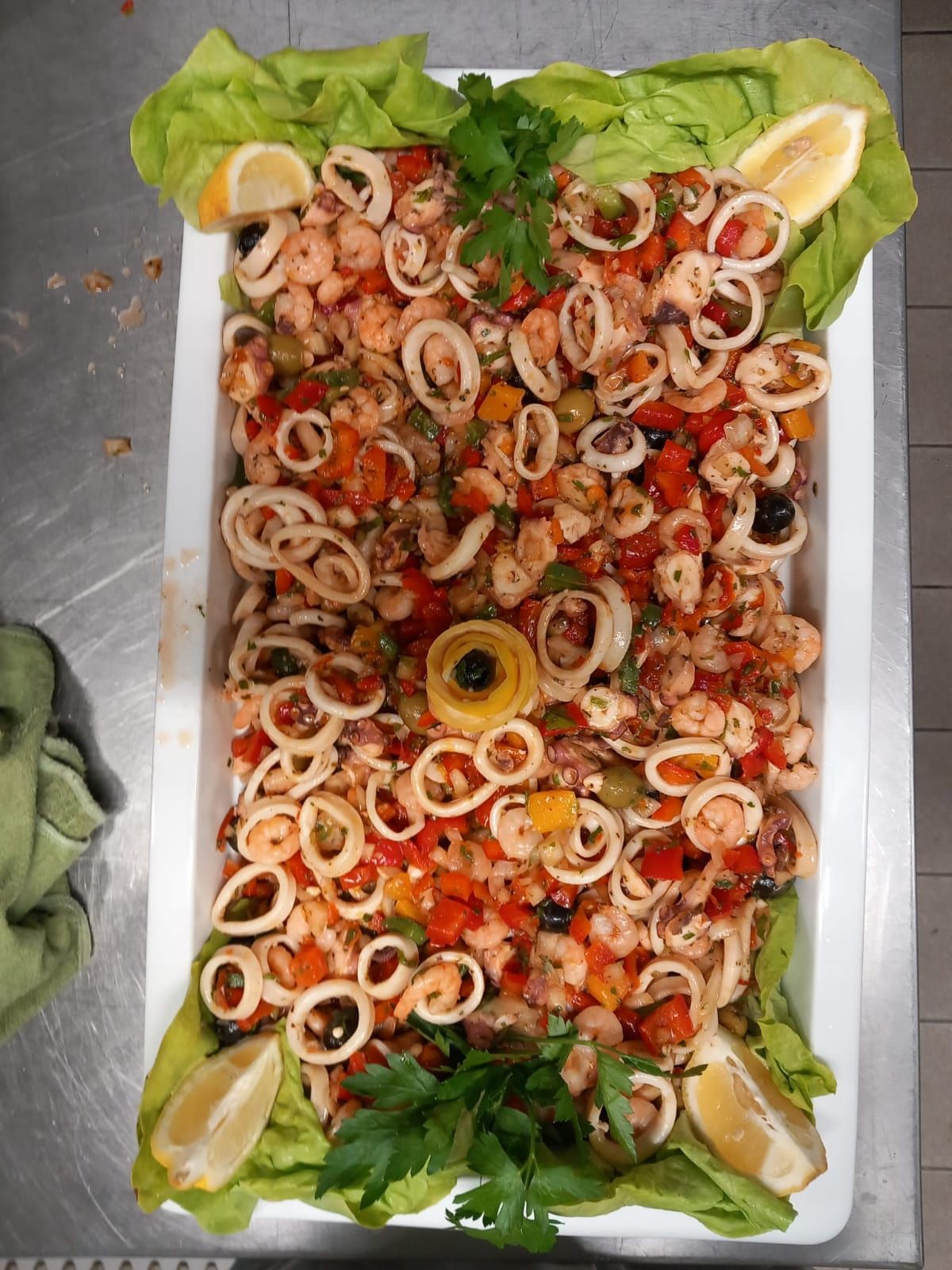 Una bandeja de ensalada de mariscos con lechuga y rodajas de limón.