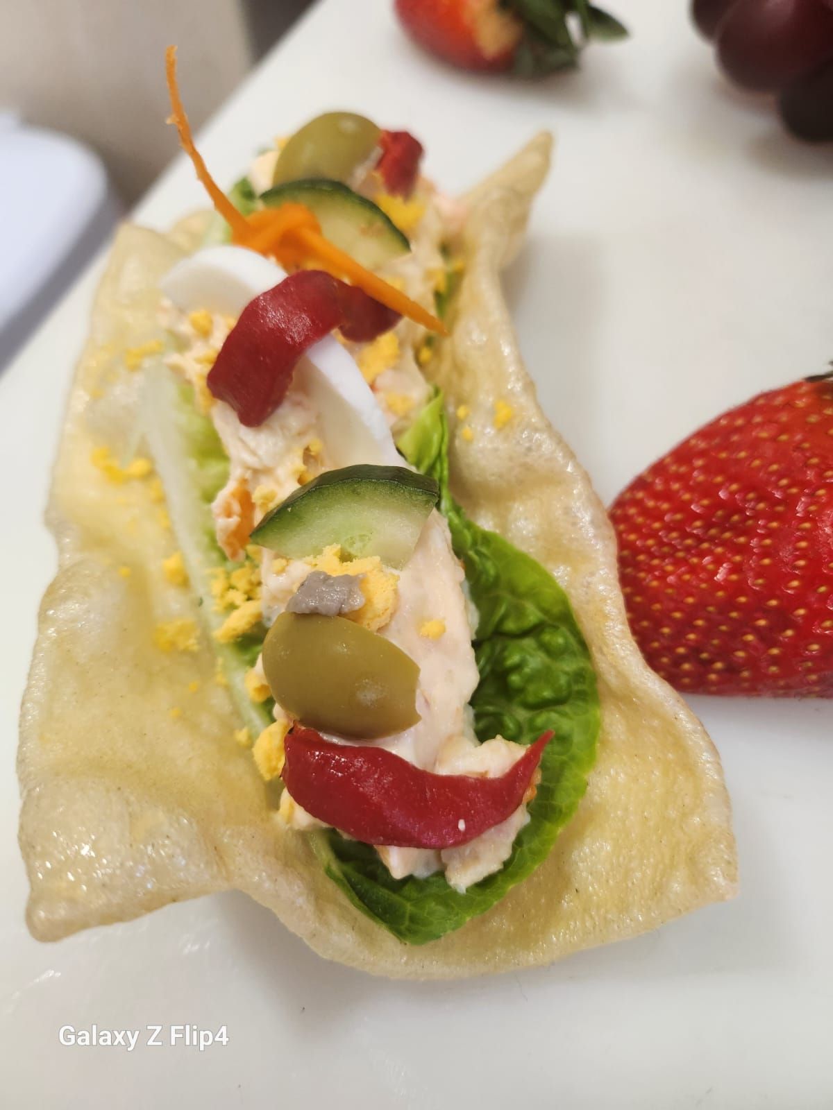 Un primer plano de un taco con una fresa al fondo.