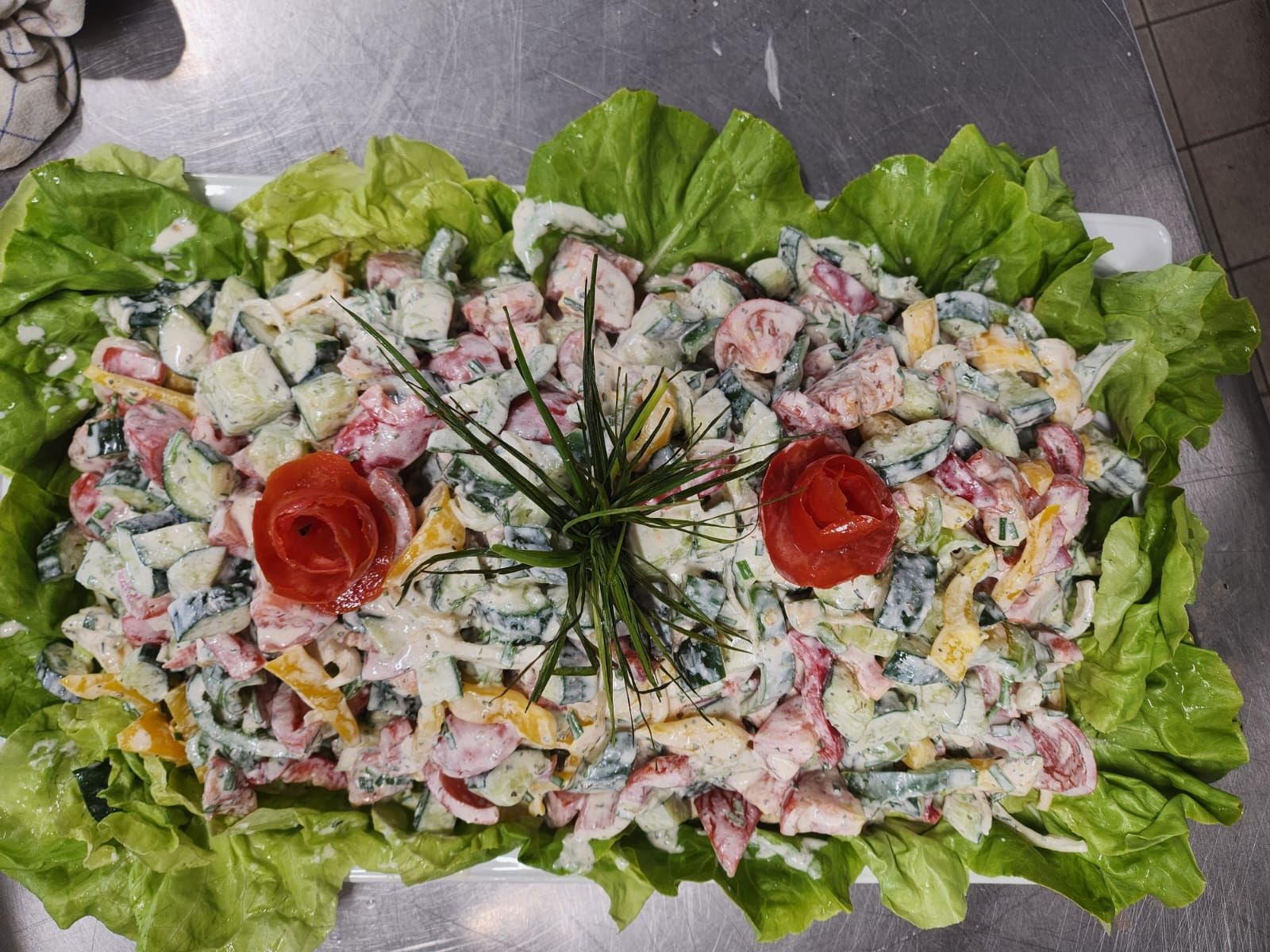 Una ensalada con lechuga y tomates en un plato sobre una mesa.