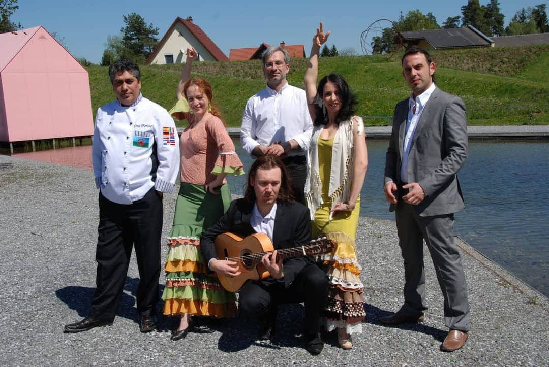 Un grupo de personas posando para una foto con un hombre sosteniendo una guitarra.