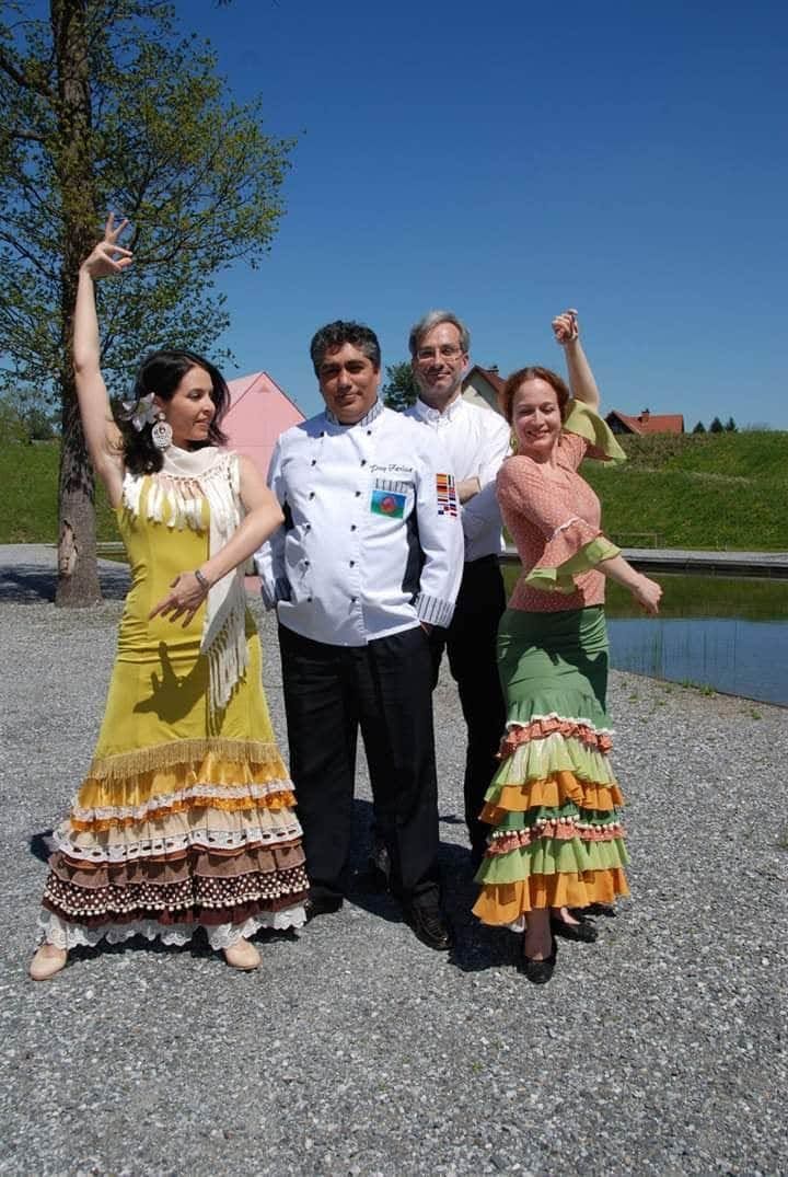 Un grupo de personas posa para una fotografía frente a un cuerpo de agua.