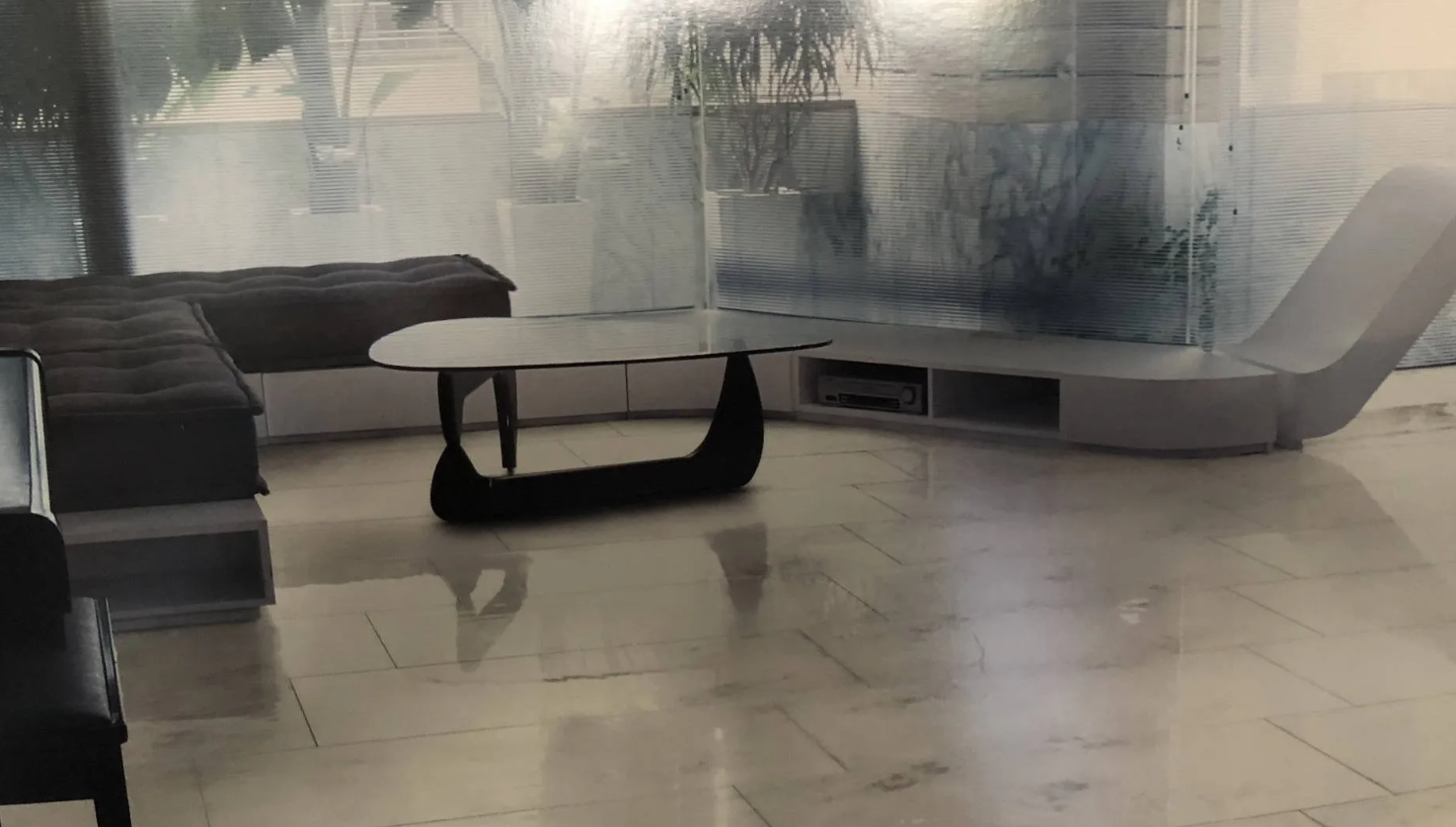 Un balcone con piastrelle bianche e un muro bianco.