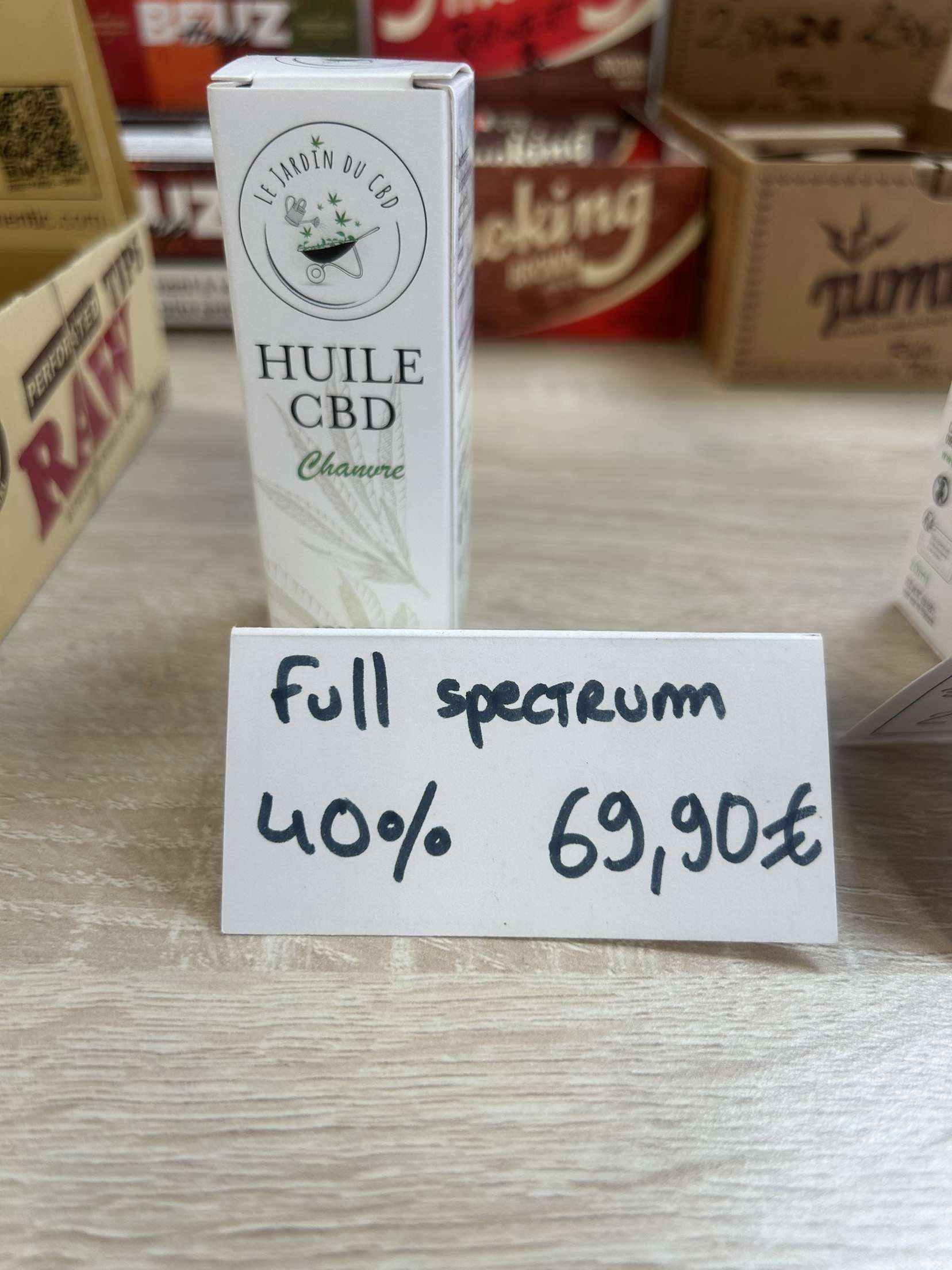 Une boîte de CBD à spectre complet est posée sur une table en bois.