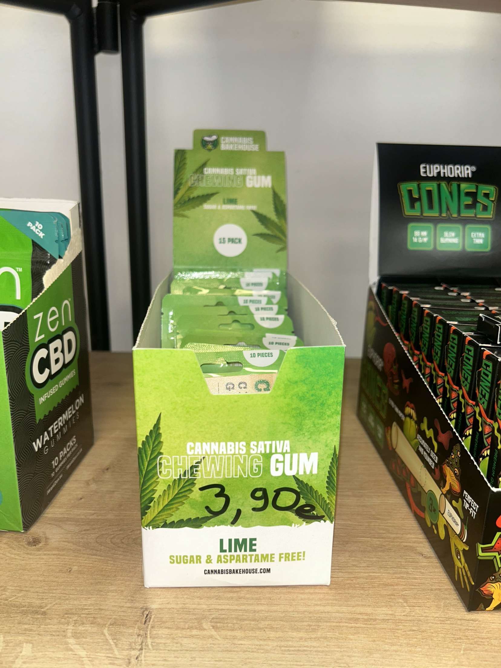 Trois boîtes de cônes de CBD sont posées sur une table en bois.