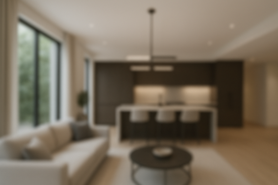 Vista interior borrosa de una sala de estar moderna con isla de cocina, sofá y mesa de centro redonda.