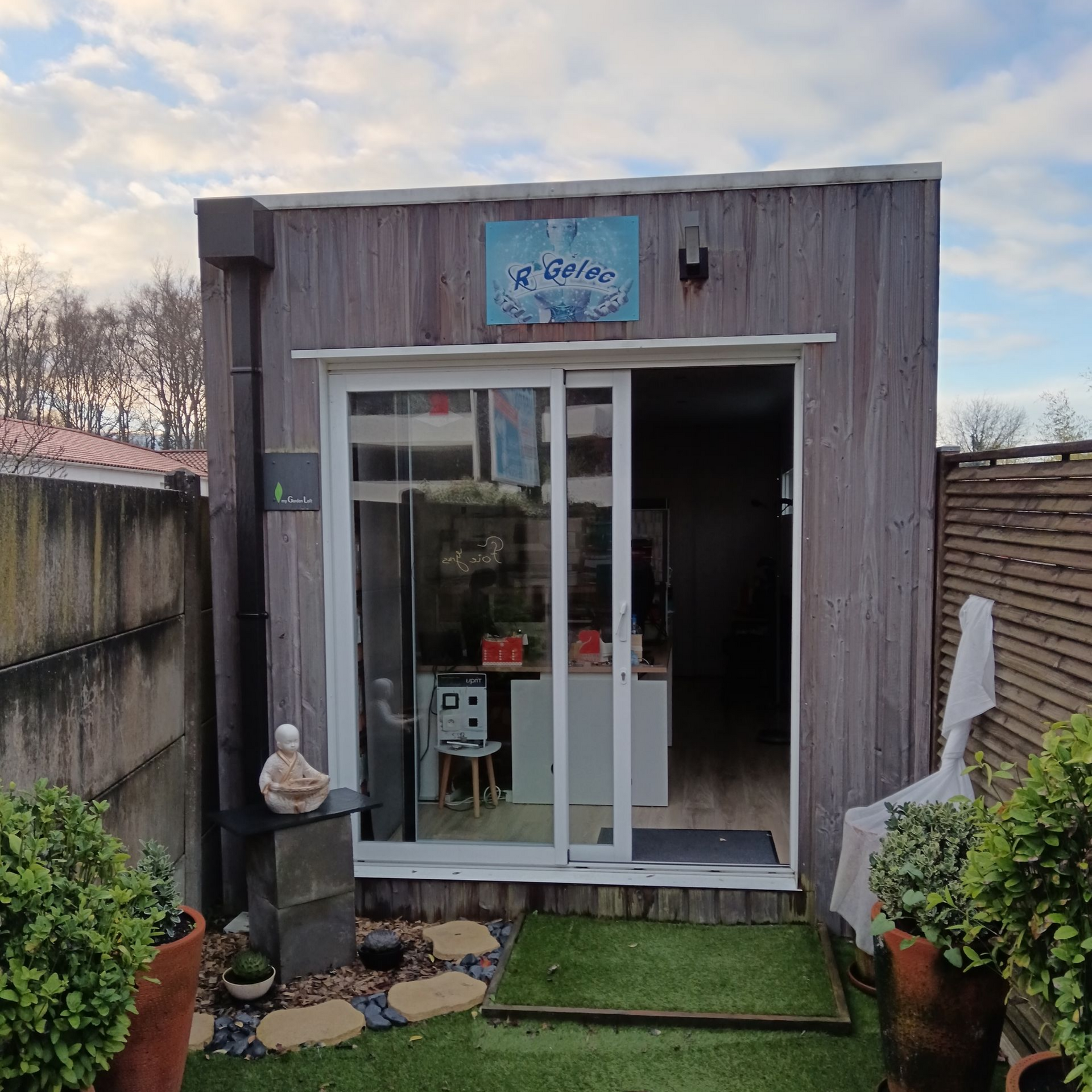 Abri de jardin en bois avec portes coulissantes en verre.