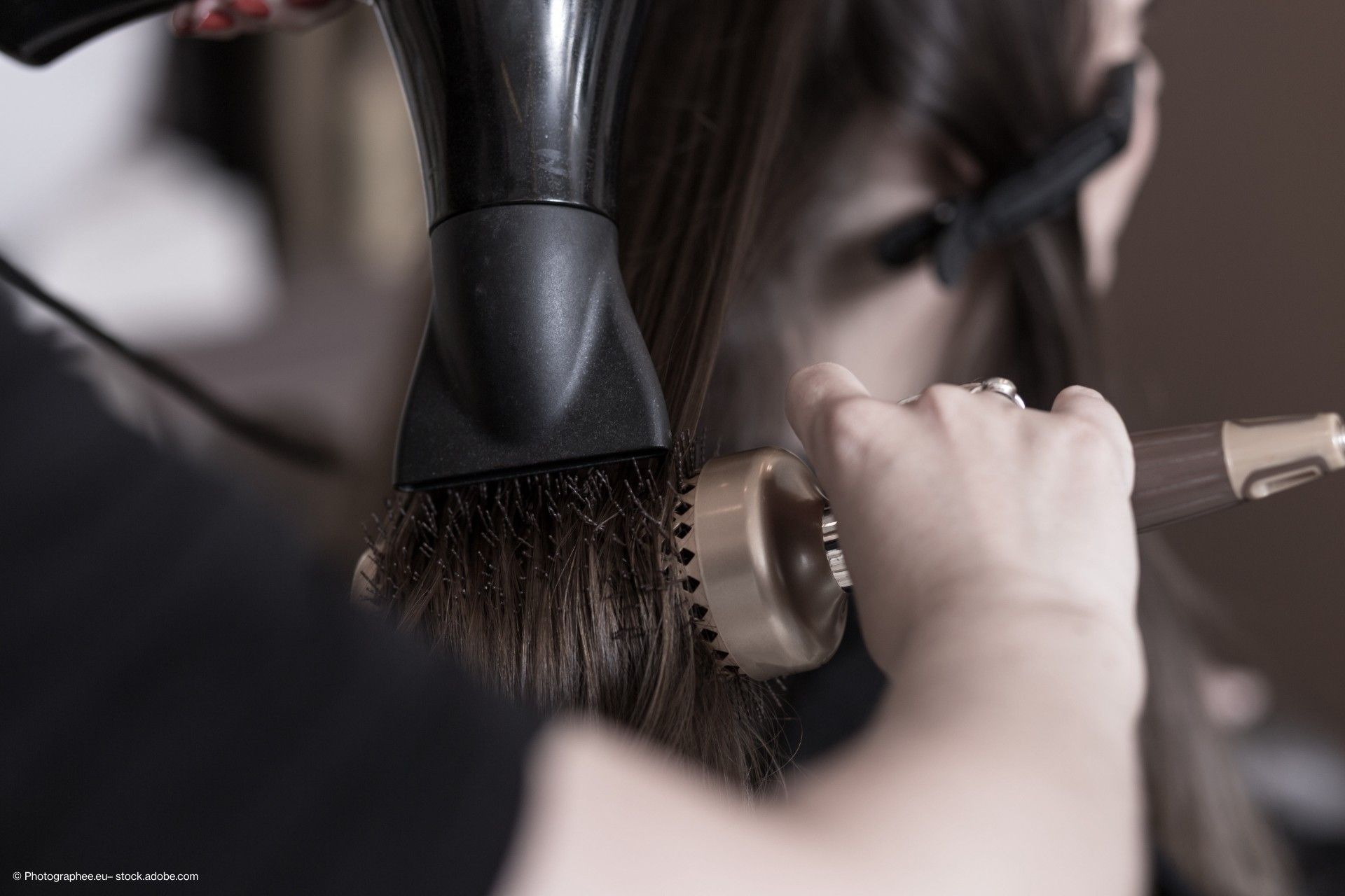 Friseur beim Föhnen und Stylen von Haaren