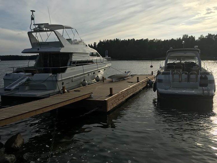 Kaksi jahtia laiturissa tyynellä vedellä auringonlaskun aikaan