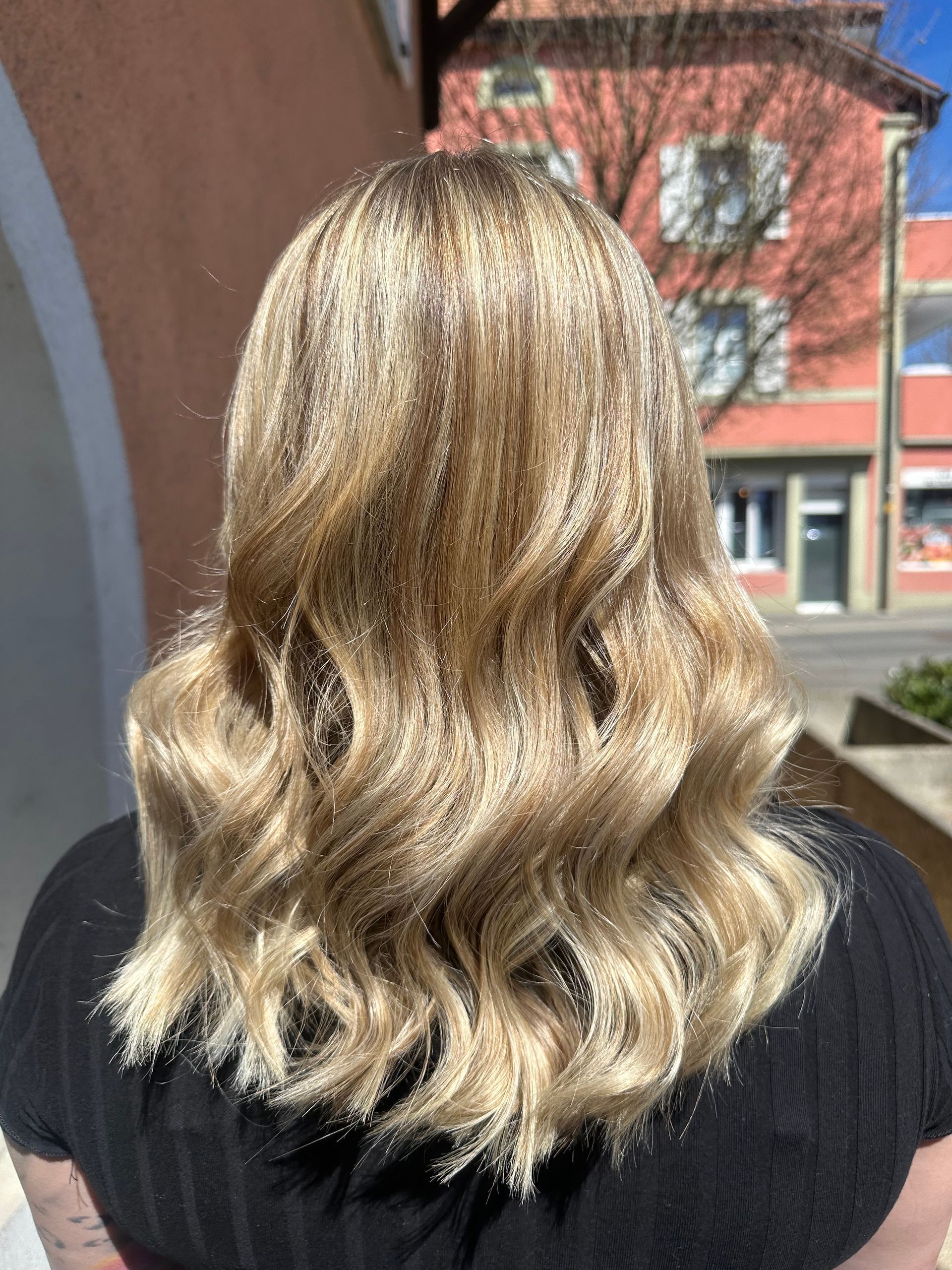 Femme de dos les cheveux bouclés et blonds