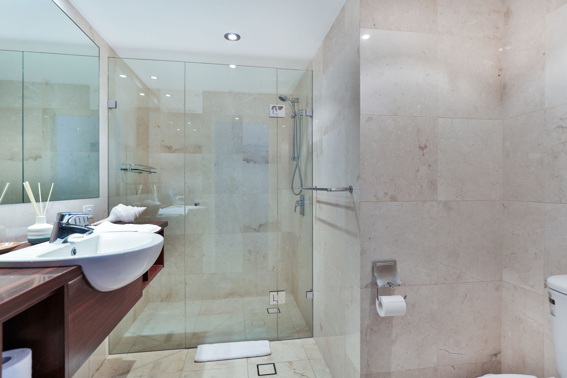 A bathroom with a walk in shower and a sink