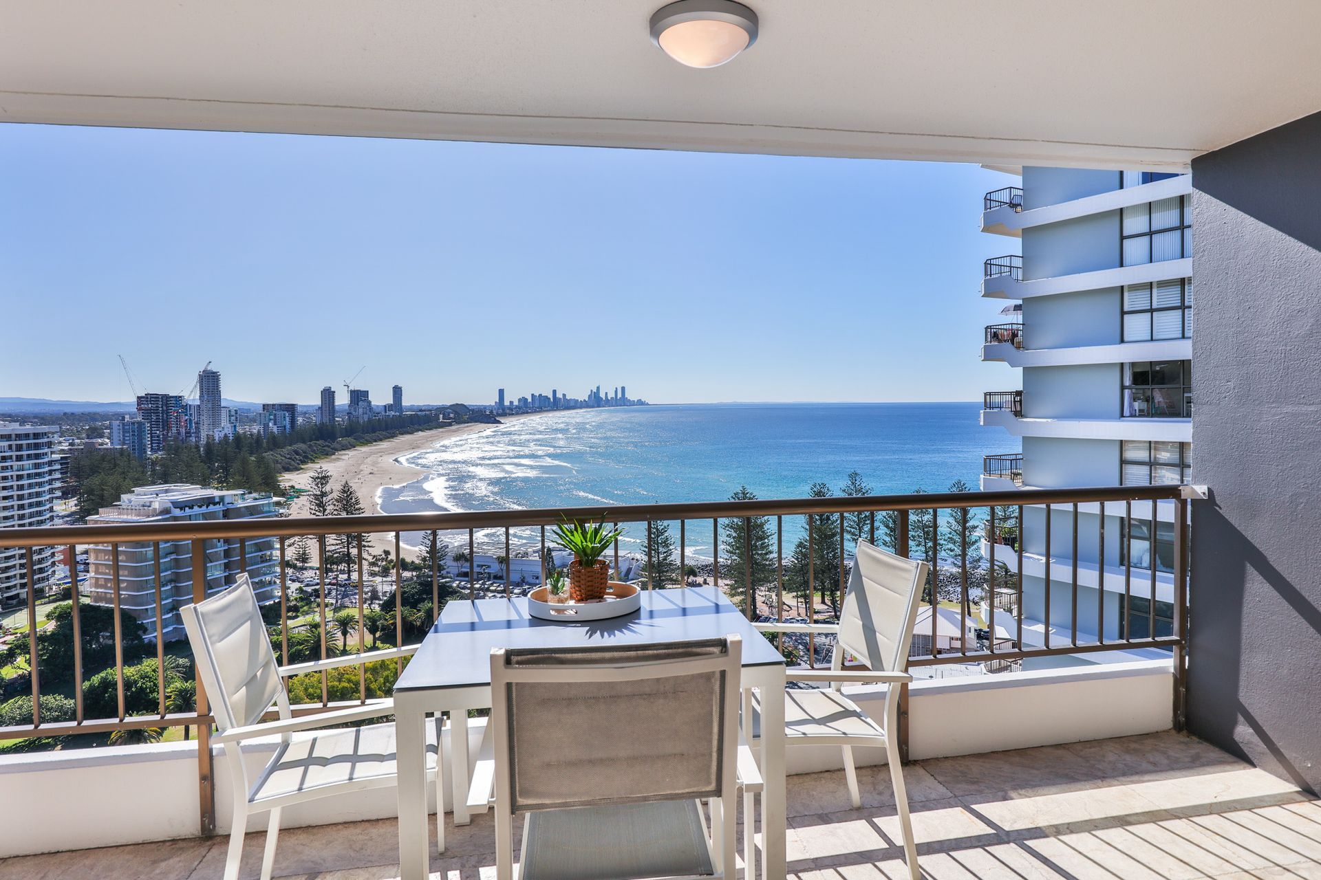 A balcony with a table and chairs overlooking the ocean