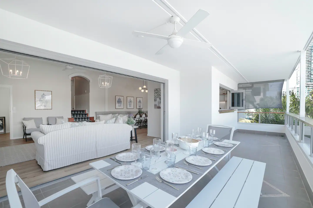 There is a dining table and bench on the balcony in the living room.